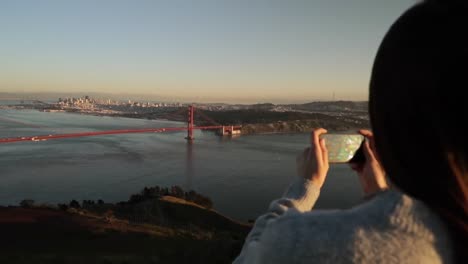 Woman-photographing-the-Golden-Gate-Bridge,-San-Francisco