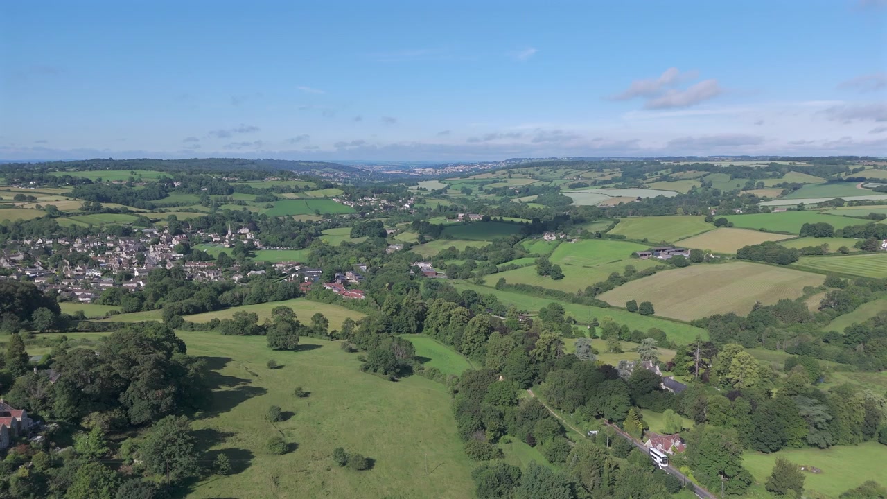Aerial ascent from Box Hill revealing Box village on a summers day