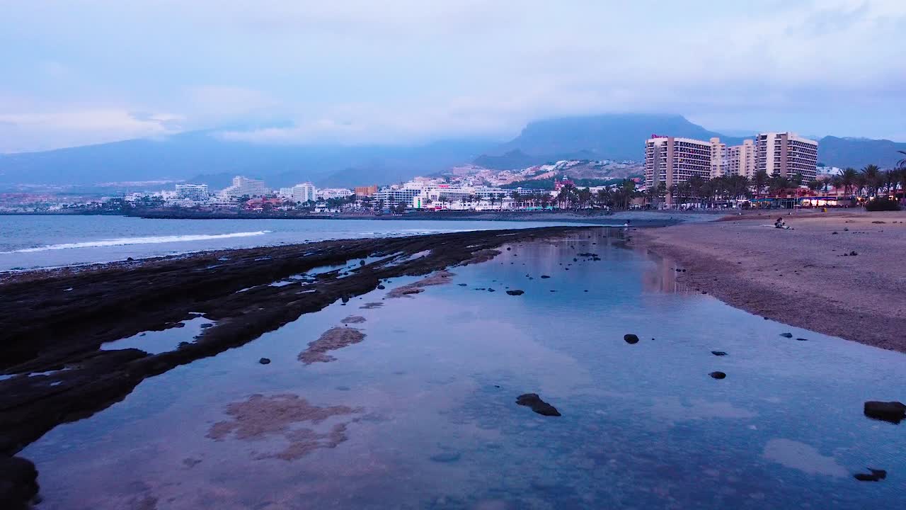 Inquadratura drone degli edifici del resort balneare di Playa de las Américas con vista turistica sullo sfondo, Santa Cruz de Tenerife, città capoluogo in Spagna.