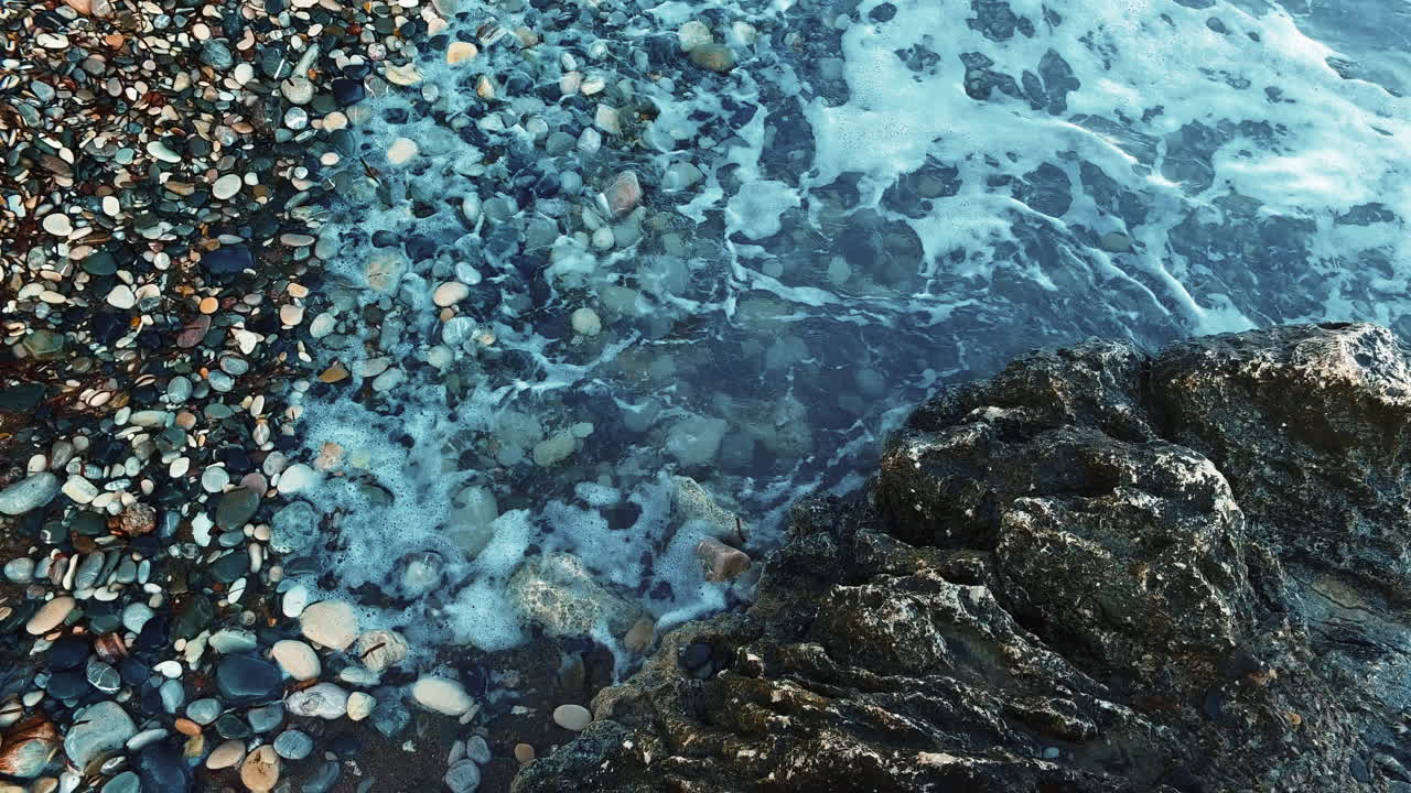 깊은 푸른 바다 물은 바위 해안선을 때립니다. 바다 파동을 가 ⁇ 게 보세요.