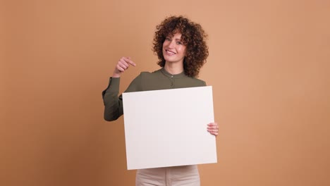 happy woman holding blank paper in beige studio