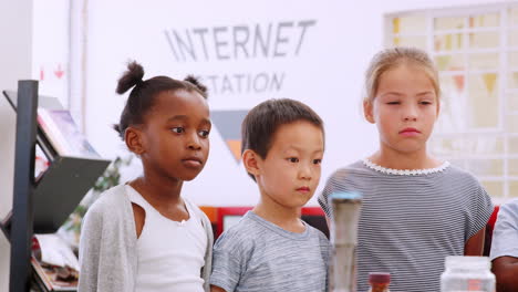 los niños ven el experimento con el quemador bunsen en el centro de ciencias.