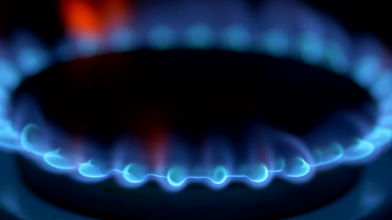 전체 어두운 방에서 가스 스토브 버너에서 파란 불꽃으로 불타는 메탄.