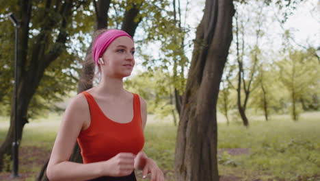 Corredor-Deportivo-De-Fitness-Atlético-Mujer-Entrenando-Carrera-De-Maratón,-Escuchando-Música-En-Auriculares-En-El-Parque