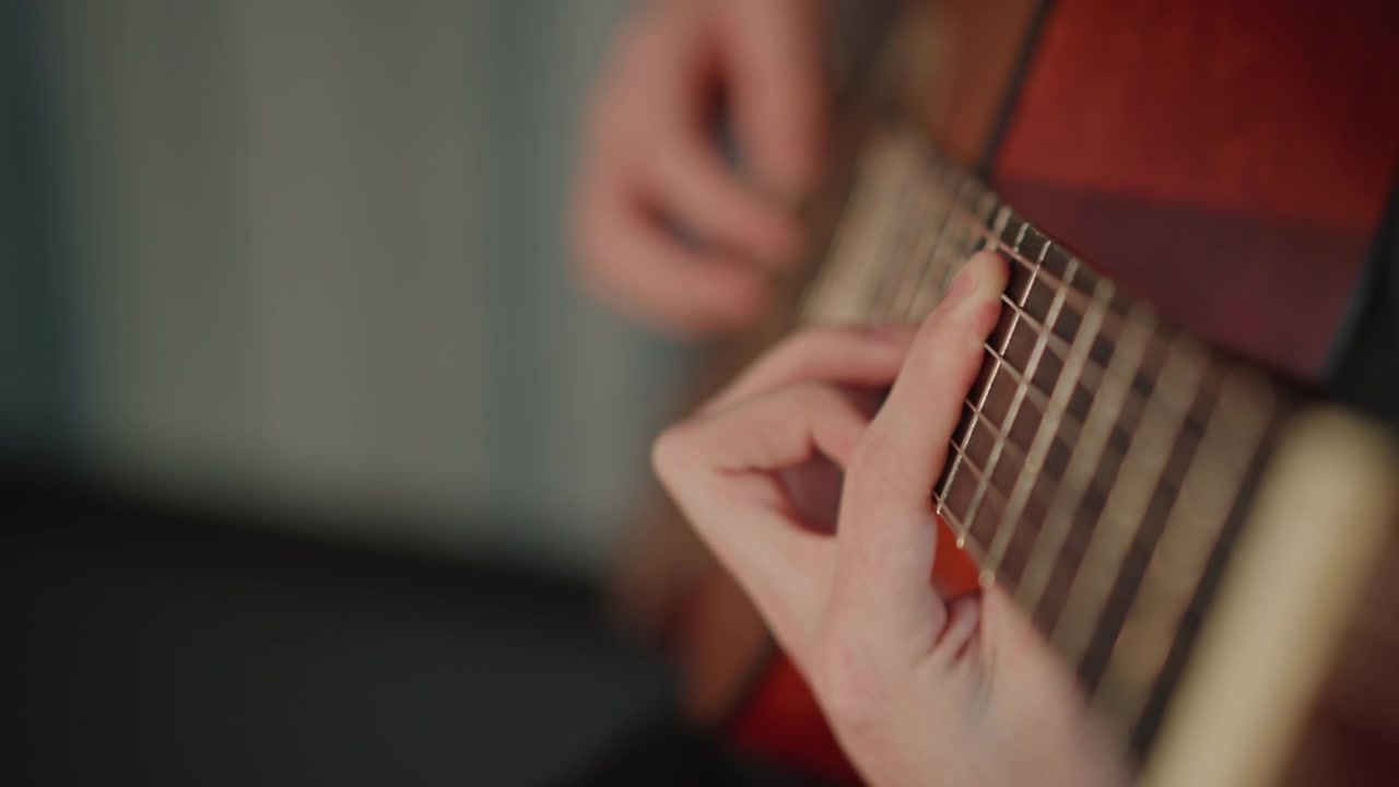Close-up da técnica de dedos no braço de violão acústico, estudante praticando escalas em estúdio silencioso, cordas de nylon em corpo de madeira quente, movimento detalhado da mão e do pulso, foco em câmera lenta na destreza.