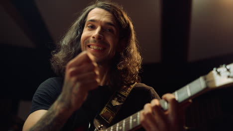 expressive man playing guitar in studio