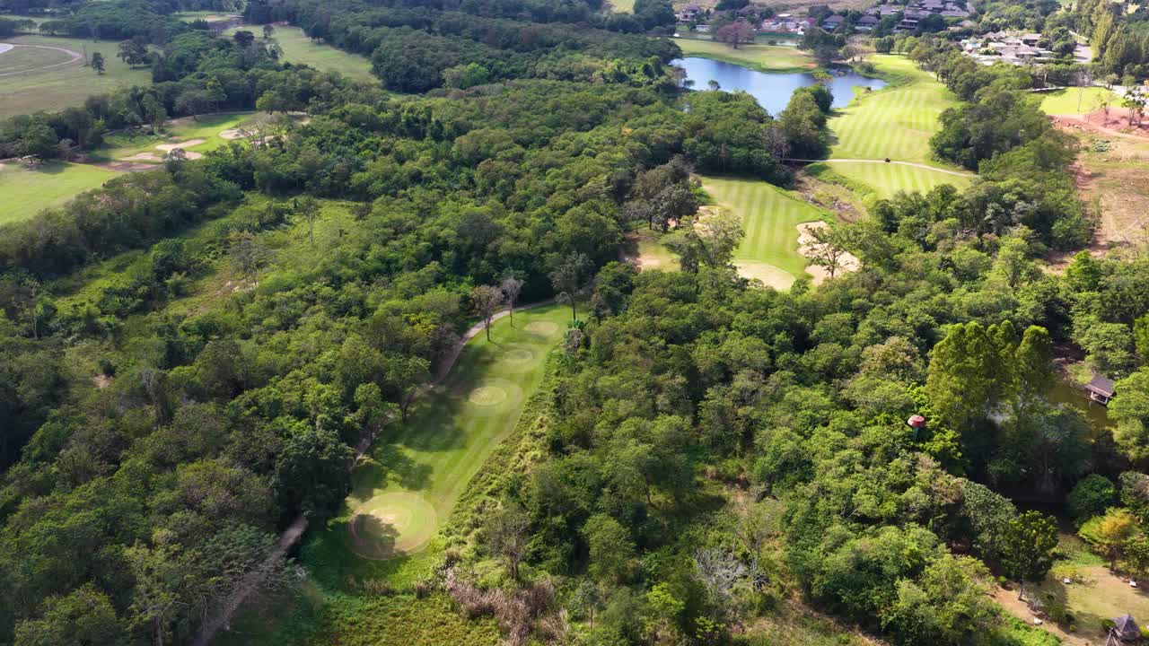 Vídeos de drones captan un campo de golf de un verde exuberante rodeado de selva tropical y villas de lujo
