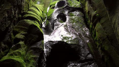 Closeup-of-a-water-flowing-over-dark-stone