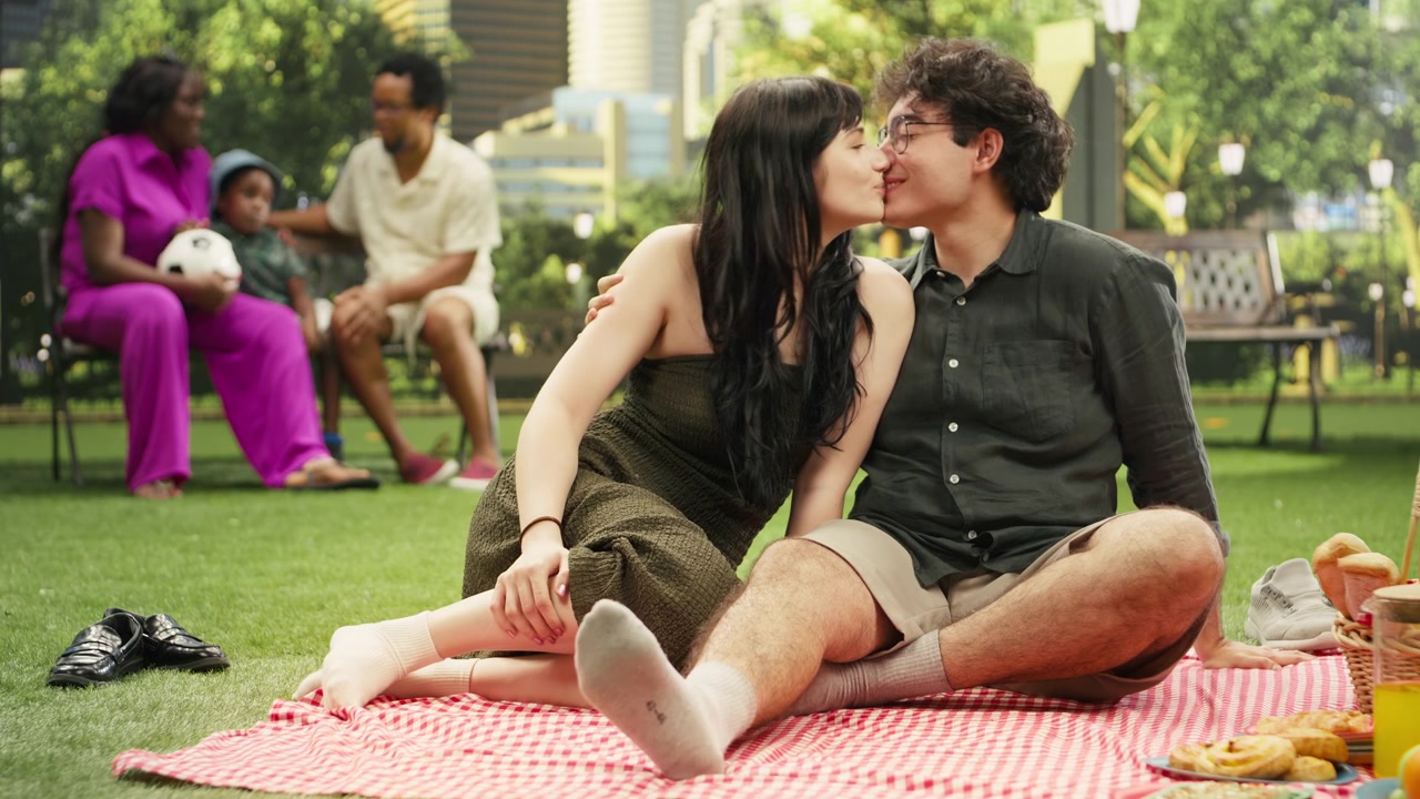 Pasangan mesra berbagi momen romantis dan berciuman saat kencan di luar ruangan