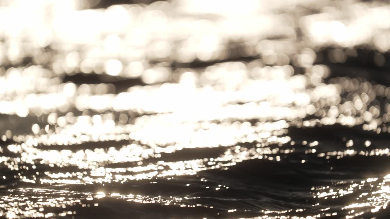 일몰 시 움직이는 파도의 추상적 얕은 초점 샷을 확대했습니다.