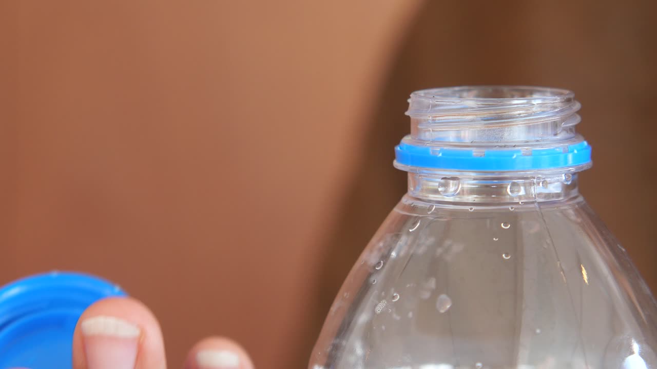 Hand closing a plastic water bottle cap