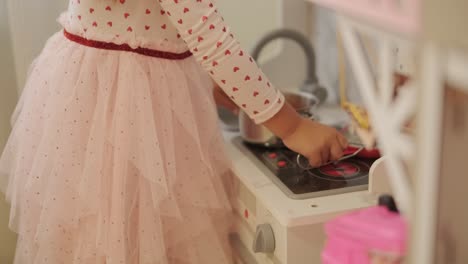 little girl playing in playroom in pretty dress