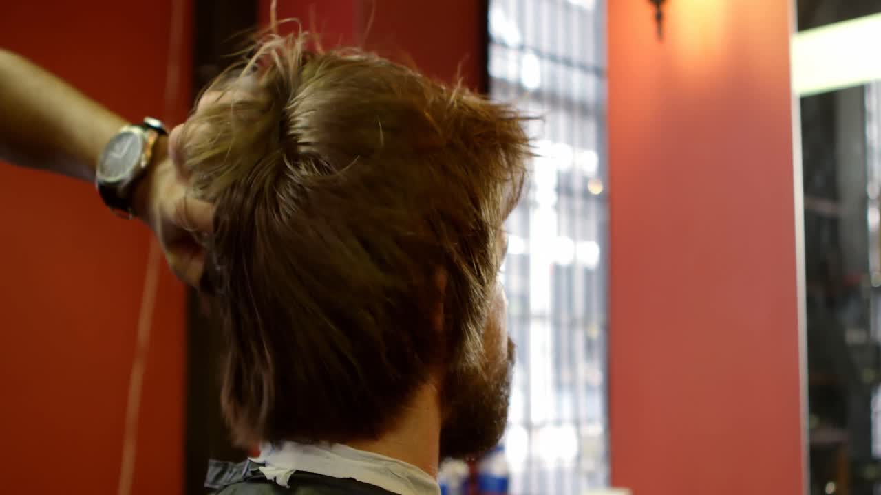 barbero secando el cabello del hombre con secador de cabello 4k