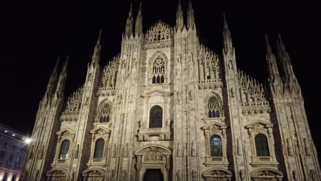 milan duomo cathedral at night tilt down view of the main facade illuminated at nighttime