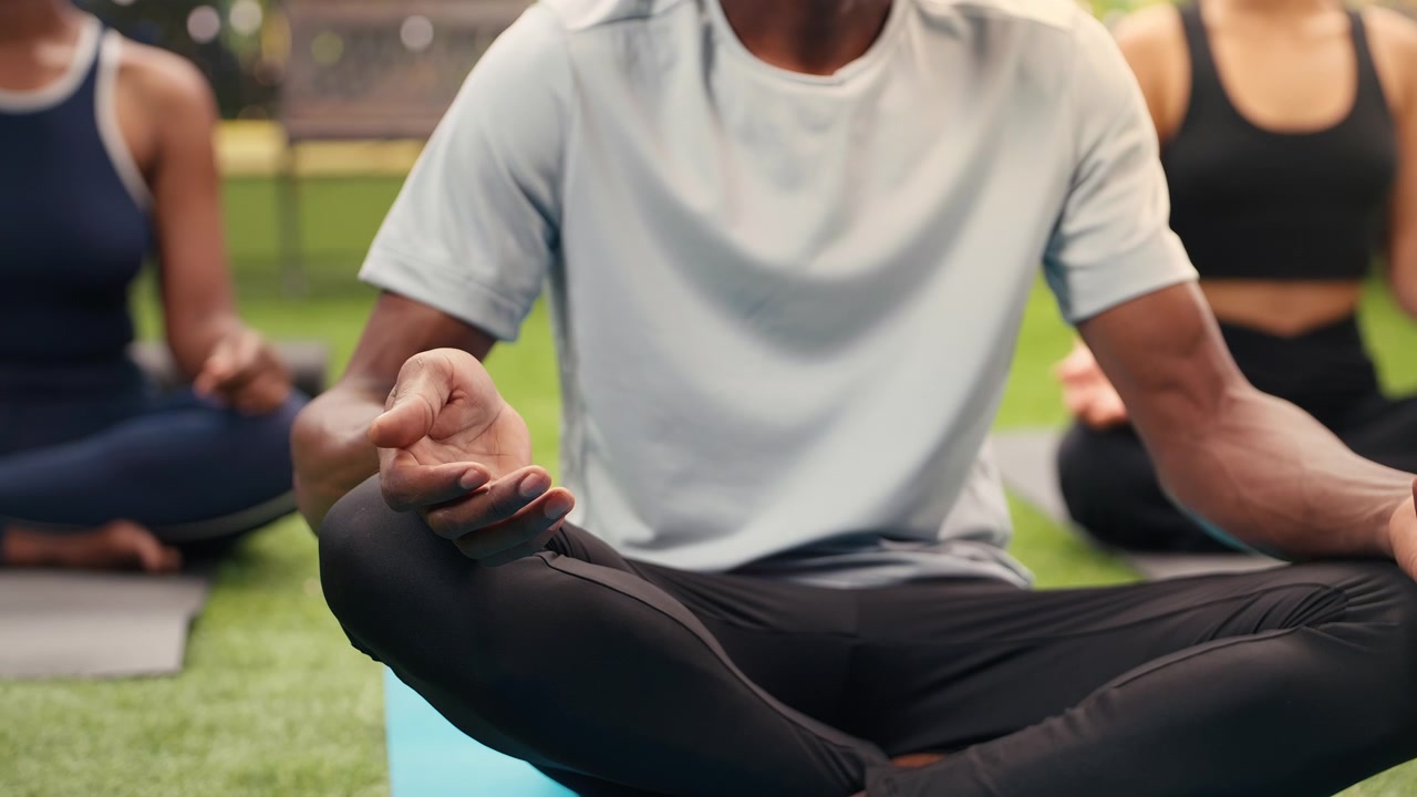 Close-up of man meditating with open palms during outdoor yoga session