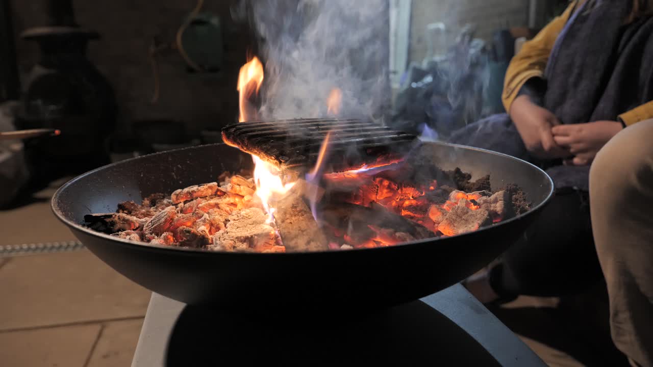 마당 에 있는 벽난로 를 둘러싸고 앉아 있는 사람 들