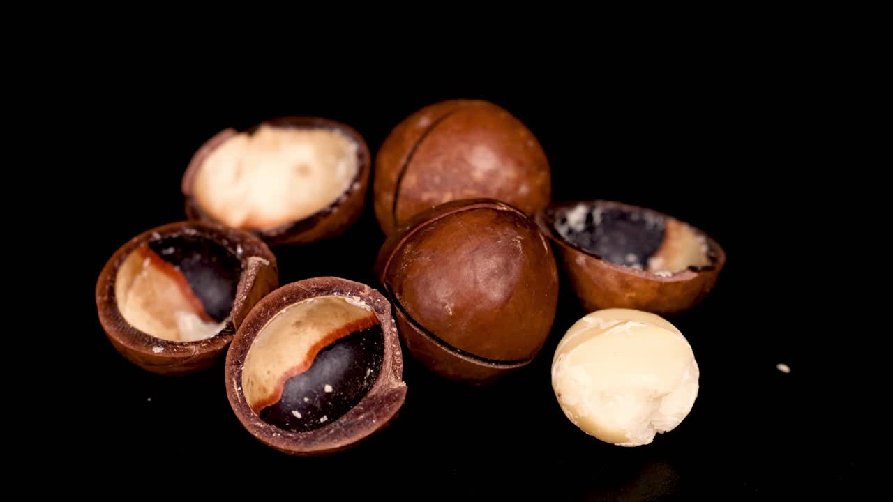 Noci di macadamia disposte su una superficie scura