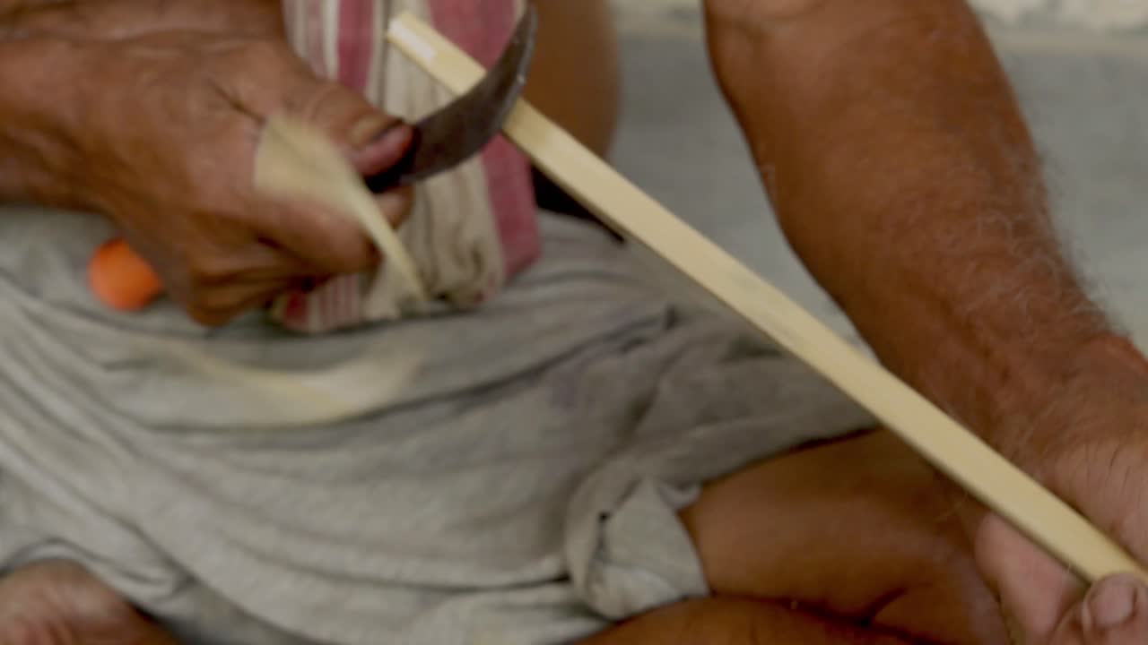 tira de bambú de un palo de madera hecha por un artesano experto usando un cuchillo afilado