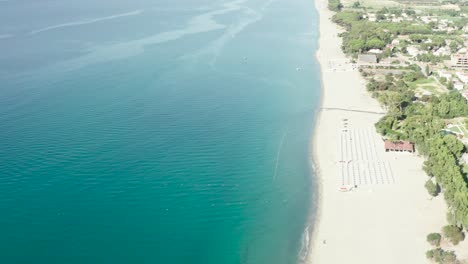 Vista-Aérea-Del-Hermoso-Mar-Mediterráneo-Y-La-Playa-En-Un-Día-Soleado,-Paisaje-Marino-Y-Montaña-En-El-Fondo,-Simeri-Mare,-Calabria,-Sur-De-Italia