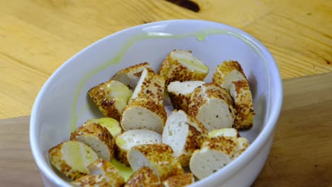 the-cook-is-in-the-kitchen-pouring-olive-oil-on-crispy-bread