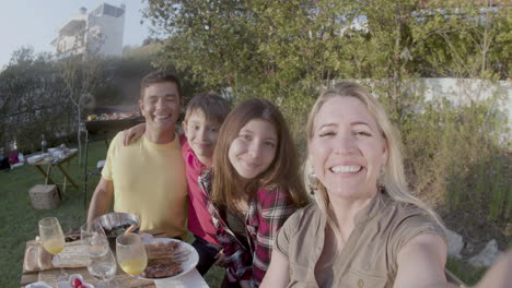 Mujer-Feliz-Tomando-Video-De-Su-Familia-En-Una-Fiesta-De-Barbacoa