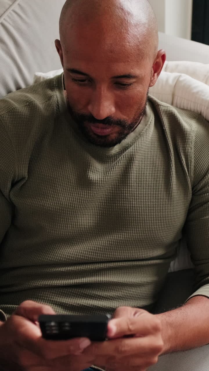 Man Relaxing on Sofa Using Phone