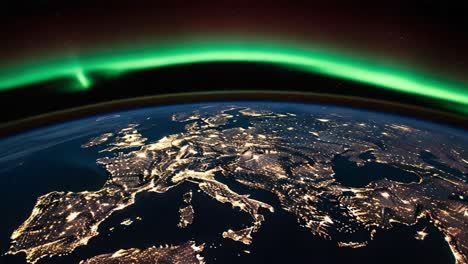nighttime view of europe from space with aurora borealis