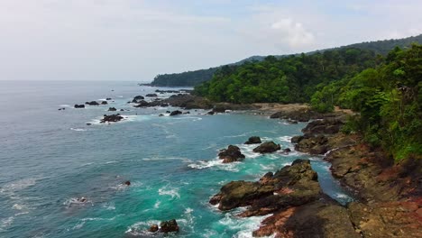 Hermosa-Jungla-Tropical-En-La-Costa-Del-Océano-Pacífico-Con-Olas-De-Agua-Azul-Turquesa-Que-Se-Estrellan-En-La-Costa-Rocosa