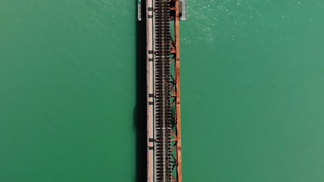 Fast-speed-train-passing-over-the-bridge-at-Okuoikojo-station-in-Tokyo,-Japan---overhead-shot