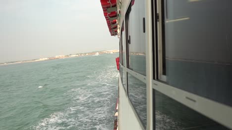 Side-view-of-a-passenger-ship-sailing-through-the-sea-in-first-person-perspective,-in-slow-motion,-with-cinematic-lighting