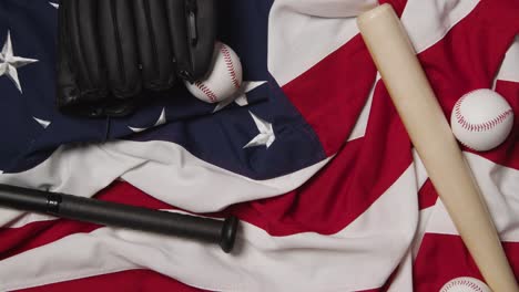 Baseball-Stillleben-über-Dem-Kopf-Mit-Schläger-Und-Ball-Auf-Amerikanischer-Flagge-Und-Person,-Die-Den-Fängerhandschuh-Aufhebt