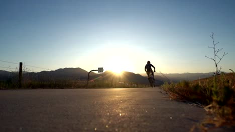 biker riding on bike trail along the highway in slow motion