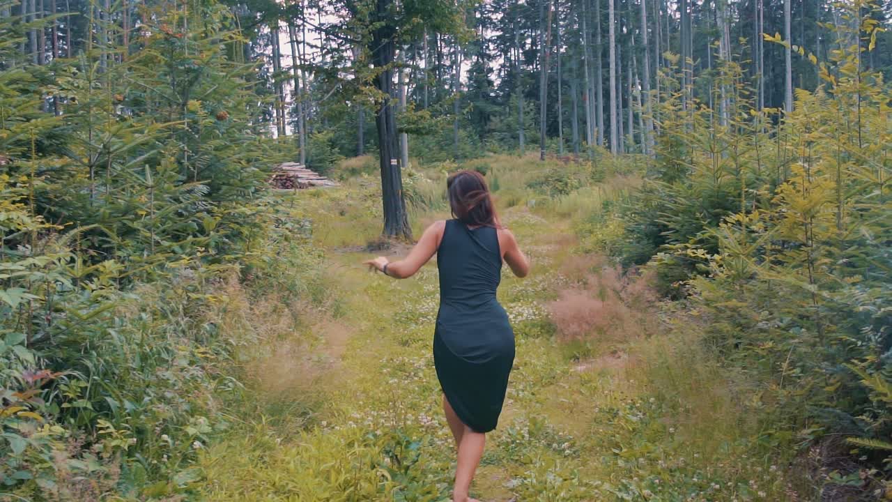 mujer bonita bailando en un bosque en cámara lenta