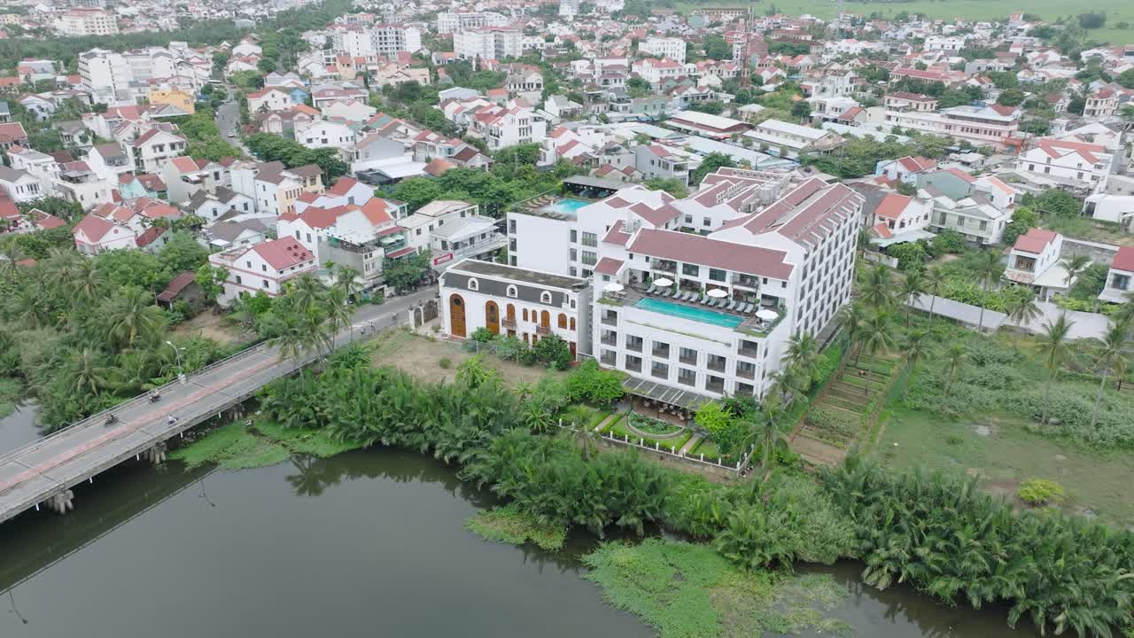 A hotel and residential area with a river in hoi an, vietnam, aerial view