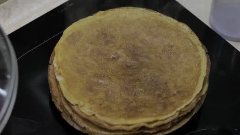 the process of cooking homemade pancakes. woman puts pancake from pan to plate