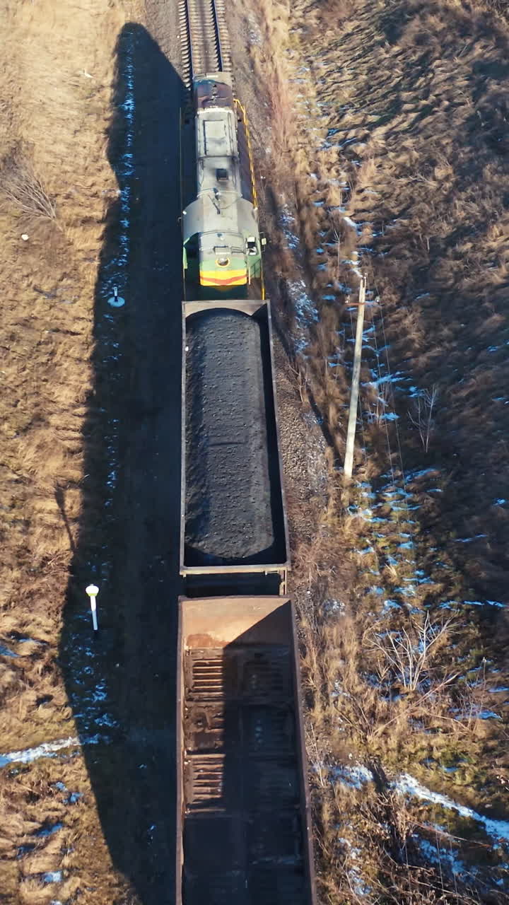 Train on railroad from above. Aerial view of train on railway track through countryside