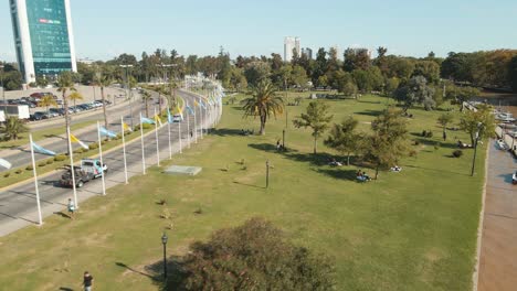 vista aérea volando rápido por un paseo costero con una avenida al lado y gente pasando el rato