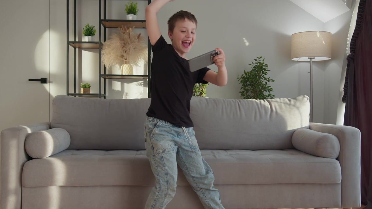 Young boy engrossed in playing a video game on a tablet device in a sunlit living room the lively