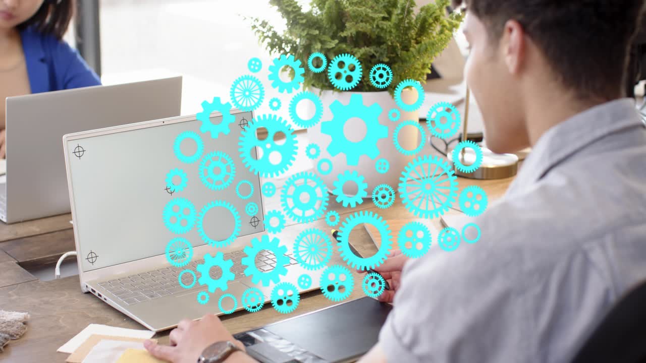 Designer tapping stylus on tablet causing teal gears overlay floating over devices guiding design