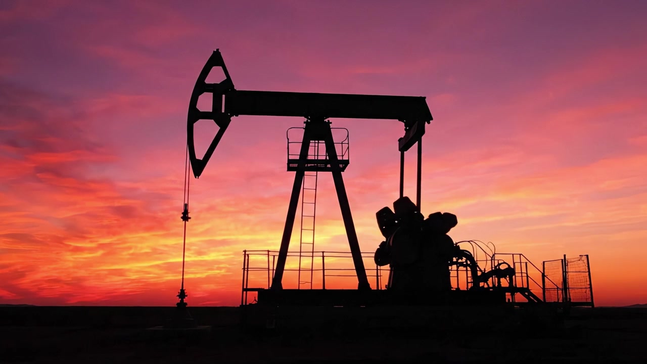 An Awe-Inspiring Silhouette of an Oil Pump Jack Against a Vivid Sunset Sky, Showcasing the Intersection of Nature and Industrial Machinery in a Captivating Landscape