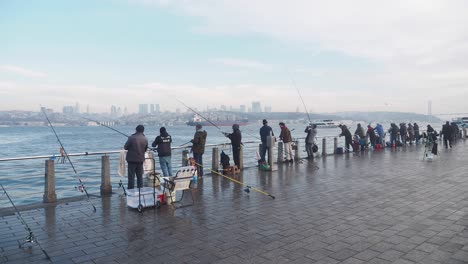 people fishing on istanbul waterfront pier in winter