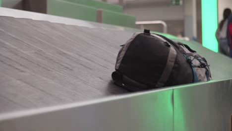 Backpack-or-luggage-on-conveyor-belt-at-airport,-baggage-claim-concept