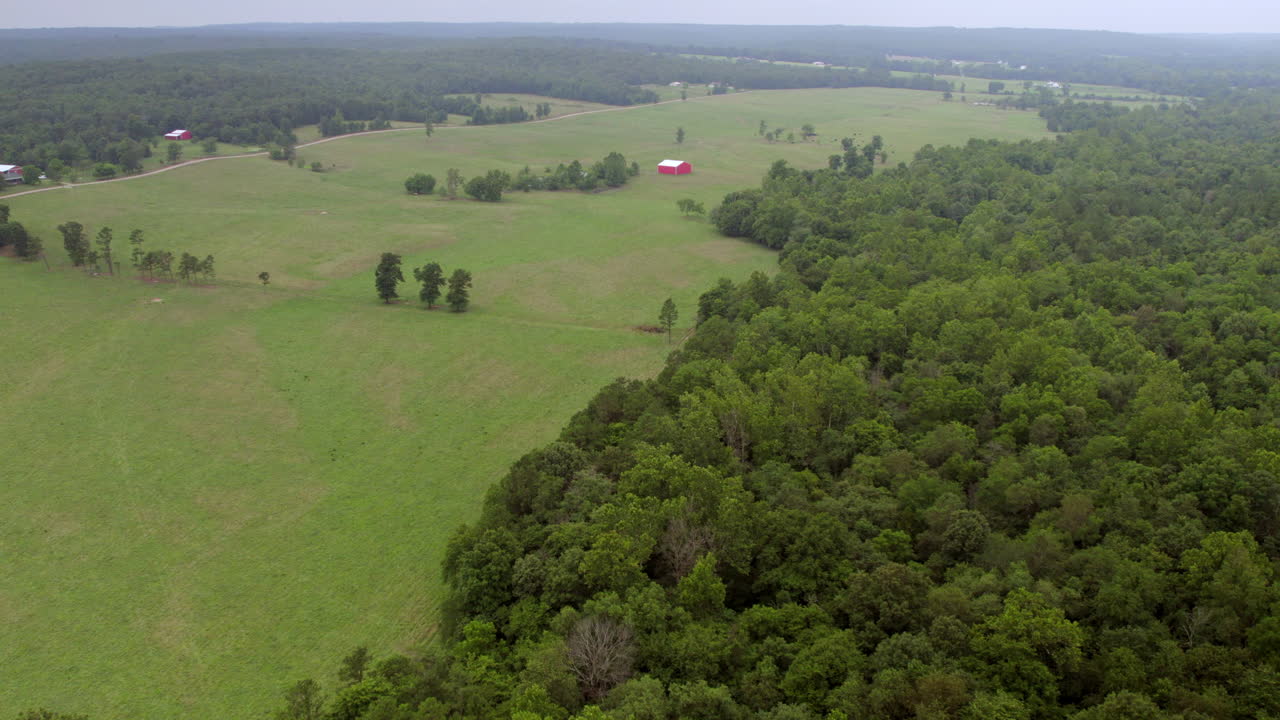 antena de tierras de cultivo y árboles en el sur de missouri con un camión de granero rojo a la derecha