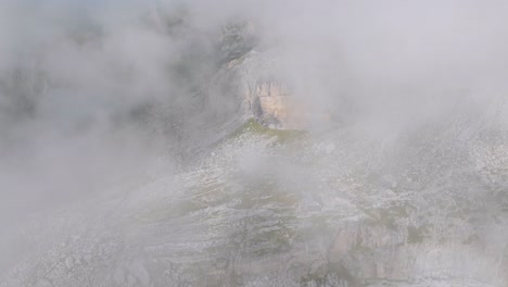 toma aérea reveladora de una cabaña para excursionistas en un valle rocoso de dolomita durante el día nublado - vista de arriba hacia abajo