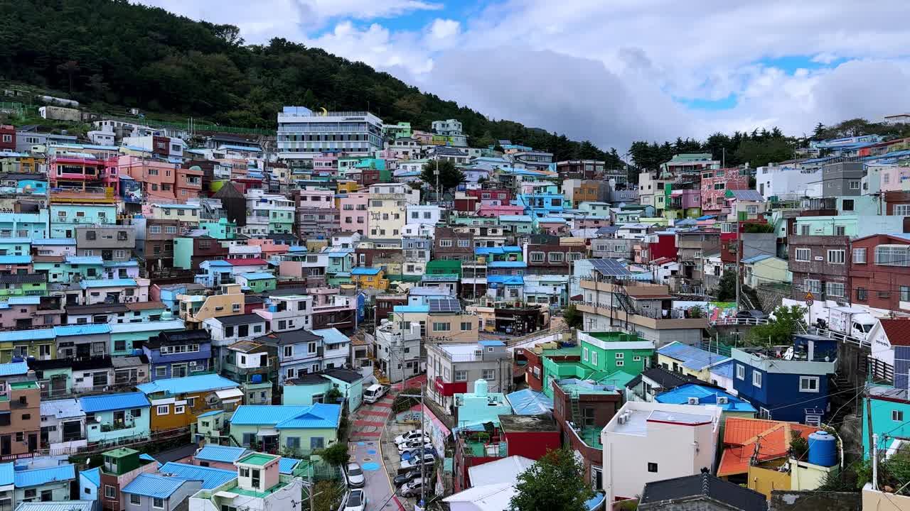 Colorful hillside houses in a densely packed residential neighborhood on a cloudy day