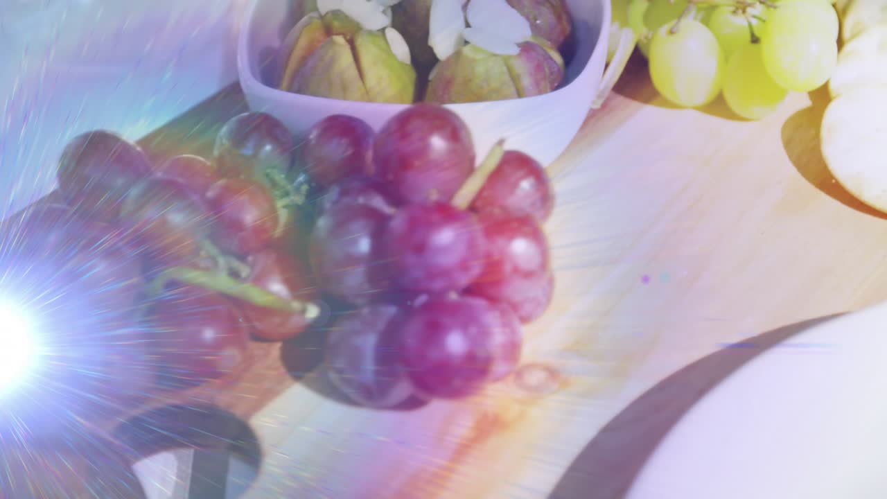 Light hitting lens creating flares glass sliding refracting colors on grapes highlighting interplay