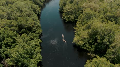 Blick-Auf-Ein-Kleines-Boot,-Das-Entlang-Des-Mangrovenflusses-Fährt,-Gesehen,-Wie-Es-Ein-Leeres-Boot-In-El-Paredon,-Guatemala,-Schleppt