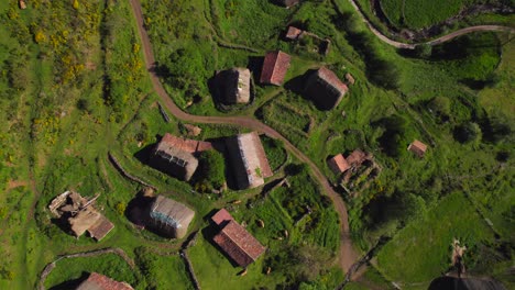 aerial top down view of rural pornacal hamlet with many old straw huts at sunset time