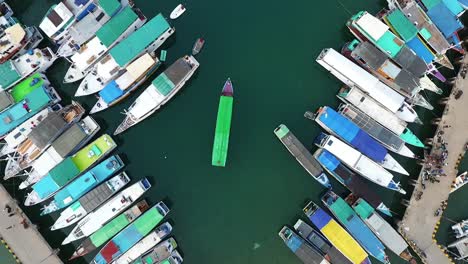 vista aérea sobre muchos barcos de pesca, en el puerto de labuan bajo, isla de flores en la región de nusa tenggara en el este de indonesia - subiendo, de arriba hacia abajo, tiro de drones