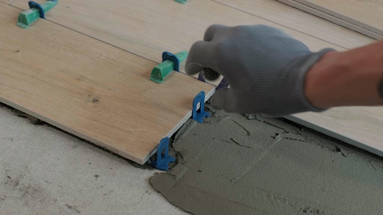 Installing ceramic floor tiles - measuring and cutting the pieces. Construction, renovation, repair apartment. Cuts tile. Tile cutting